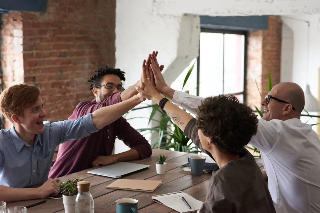 people high-fiving in business meeting